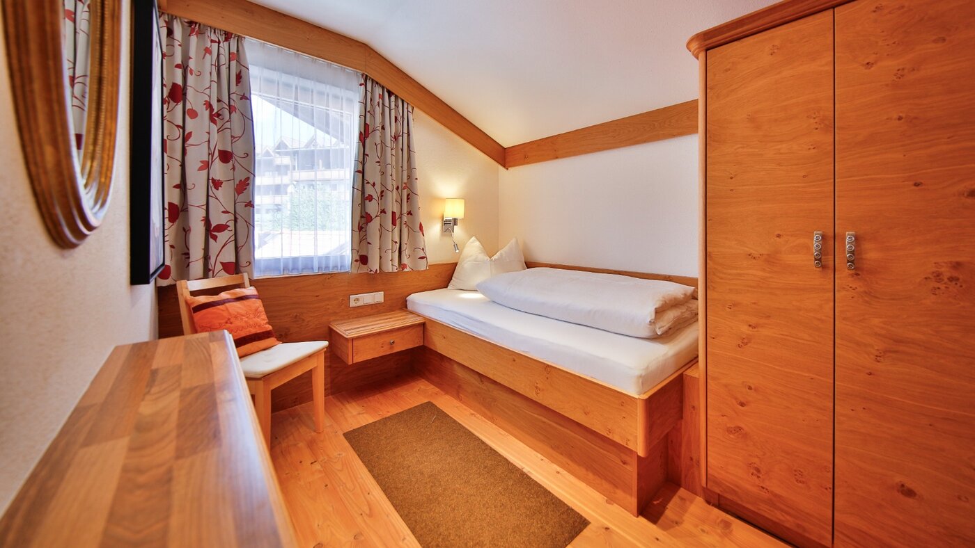 Zimmer mit Bett und rotem Teppich