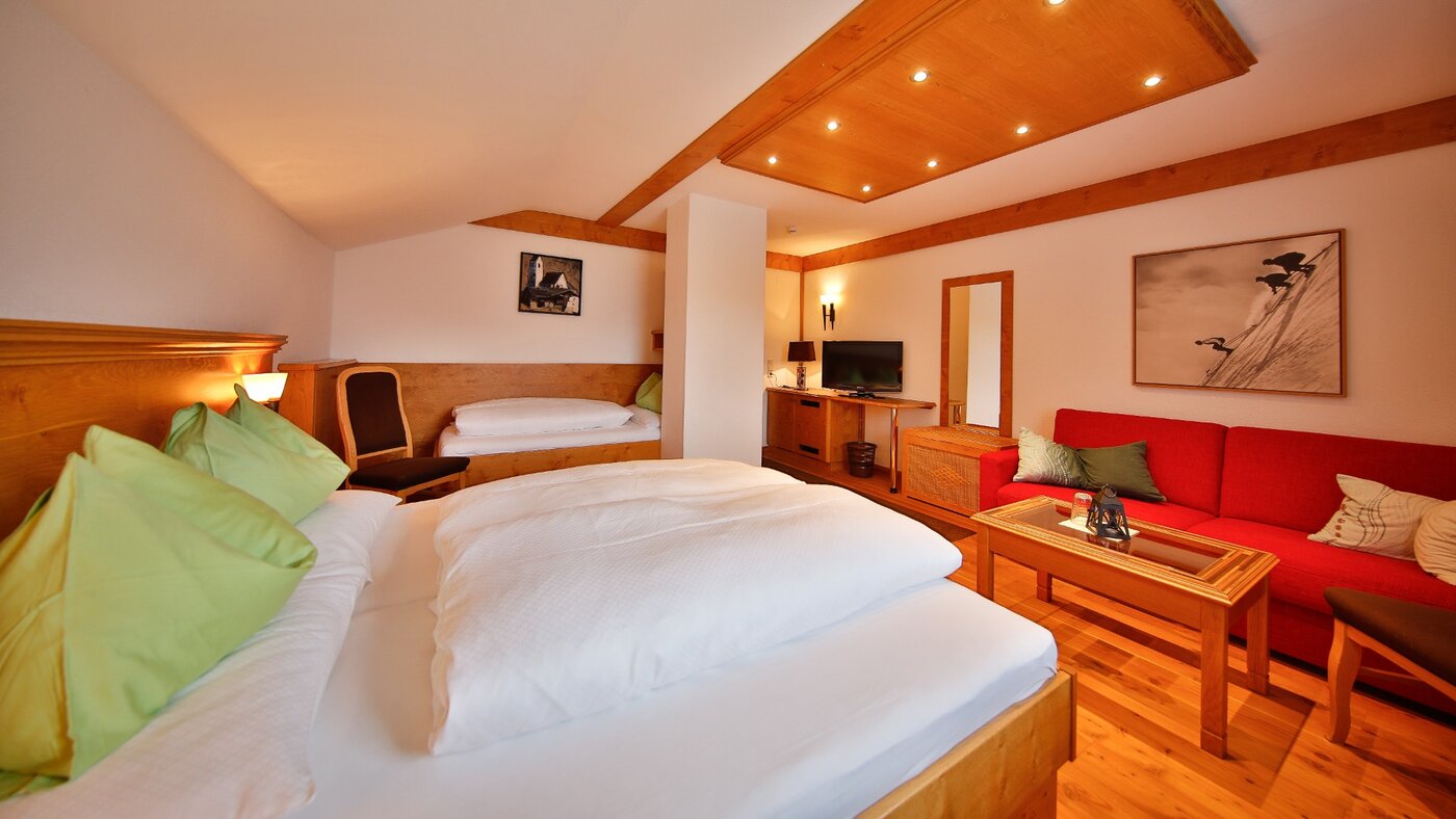 Zimmer mit Bett und rotem Sofa